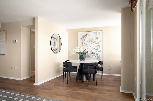 dining space featuring baseboards and wood finished floors