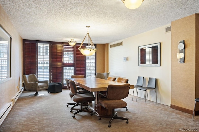 dining area with a textured ceiling, baseboard heating, and visible vents