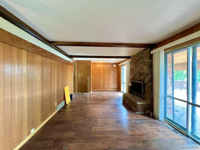 7245 S Dexter St, Centennial, CO 80122 - unfurnished living room featuring wood walls, beamed ceiling, dark wood-style flooring, and a fireplace