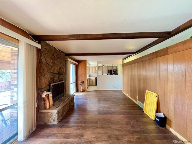 7245 S Dexter St, Centennial, CO 80122 - unfurnished living room featuring wood finished floors, plenty of natural light, beam ceiling, wood walls, and a stone fireplace