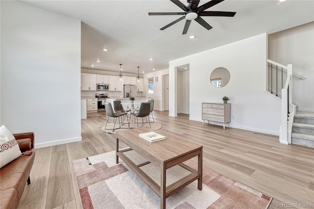 living room featuring light hardwood / wood-style floors and ceiling fan