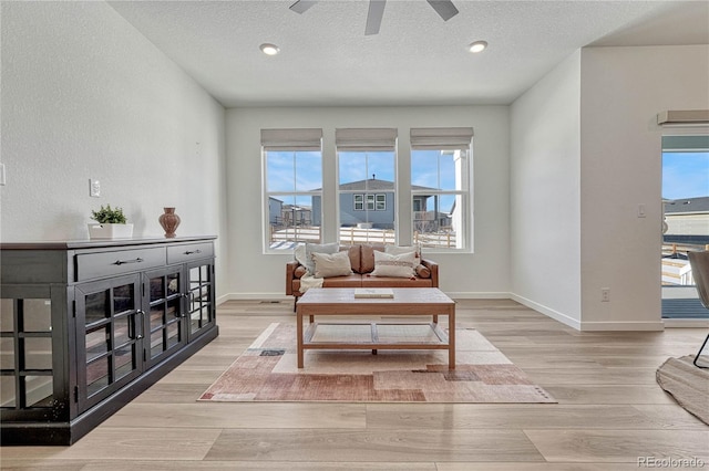 sitting room featuring ceiling fan, a textured ceiling, and light wood-type flooring