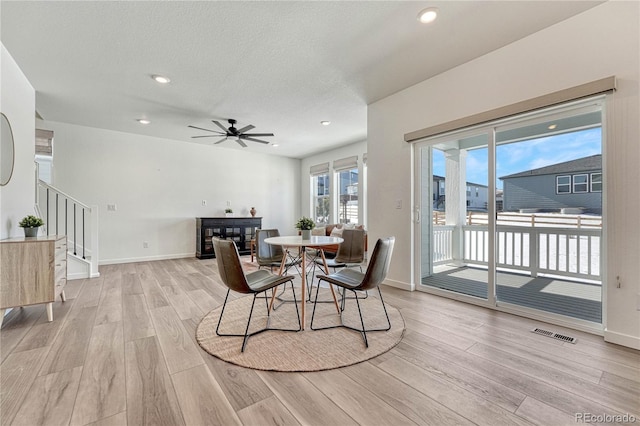 dining area featuring a textured ceiling, ceiling fan, and light hardwood / wood-style flooring