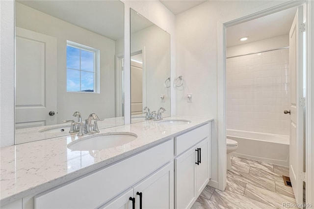 full bathroom with vanity, toilet, and tiled shower / bath combo