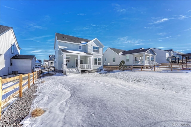 snow covered house featuring covered porch