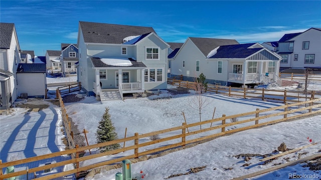 snow covered back of property featuring covered porch