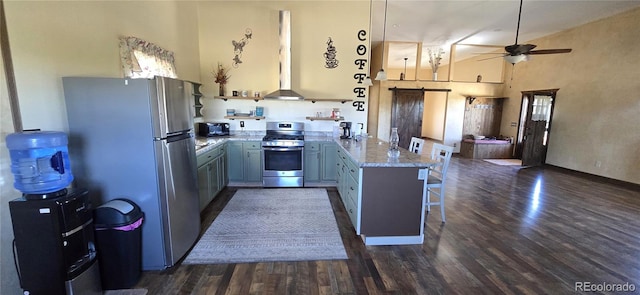 2738 Elk Park Rd, San Luis, CO 81152 - kitchen featuring stainless steel appliances, a peninsula, a barn door, ceiling fan, and a kitchen bar