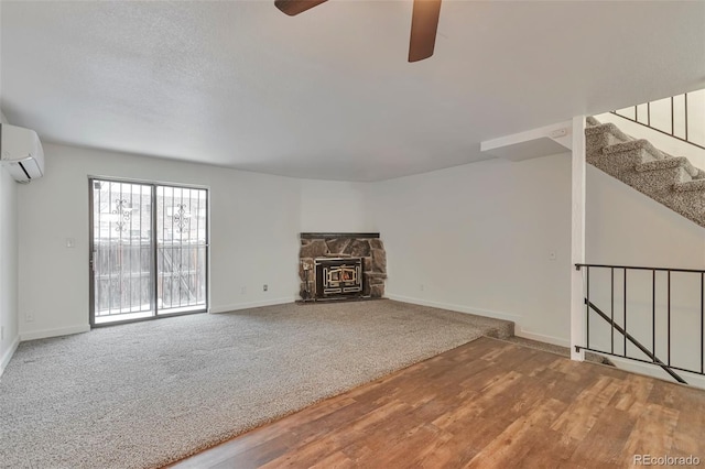 unfurnished living room featuring carpet, a wood stove, an AC wall unit, and ceiling fan