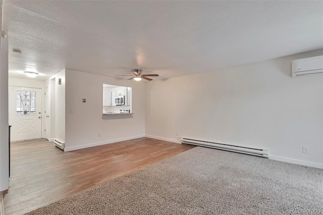 unfurnished room with ceiling fan, light hardwood / wood-style floors, a textured ceiling, and a baseboard heating unit