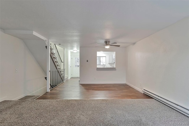 carpeted empty room featuring a textured ceiling, a baseboard radiator, and ceiling fan