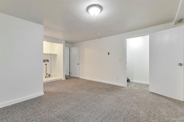 carpeted empty room featuring a textured ceiling