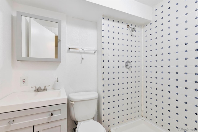 bathroom featuring toilet, vanity, and walk in shower