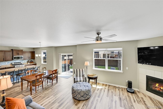 7888 E 139th Pl, Brighton, CO 80602 - living area with light wood-style floors, ceiling fan, and a fireplace