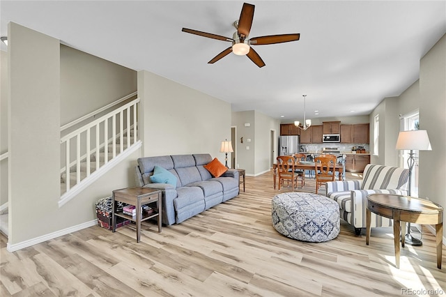 7888 E 139th Pl, Brighton, CO 80602 - living area with light wood-style flooring, ceiling fan, stairs, a chandelier, and recessed lighting