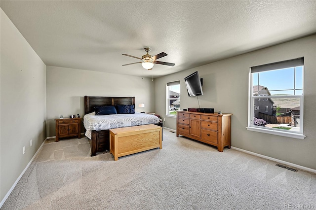 7888 E 139th Pl, Brighton, CO 80602 - bedroom featuring multiple windows, light colored carpet, a textured ceiling, and a ceiling fan