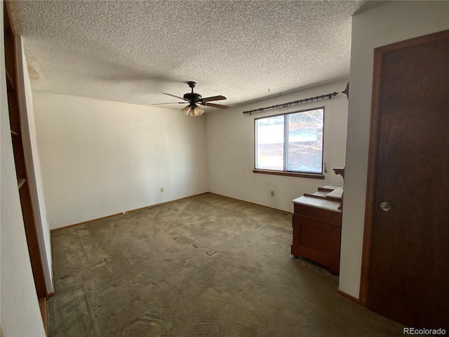 carpeted spare room with a textured ceiling and ceiling fan