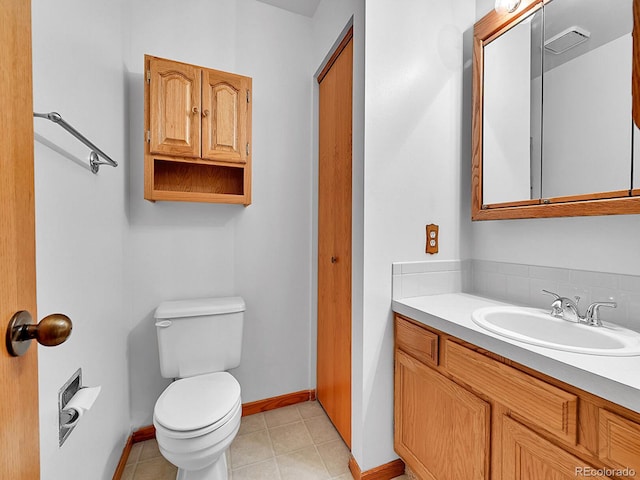 bathroom with tile patterned flooring, vanity, toilet, and baseboards