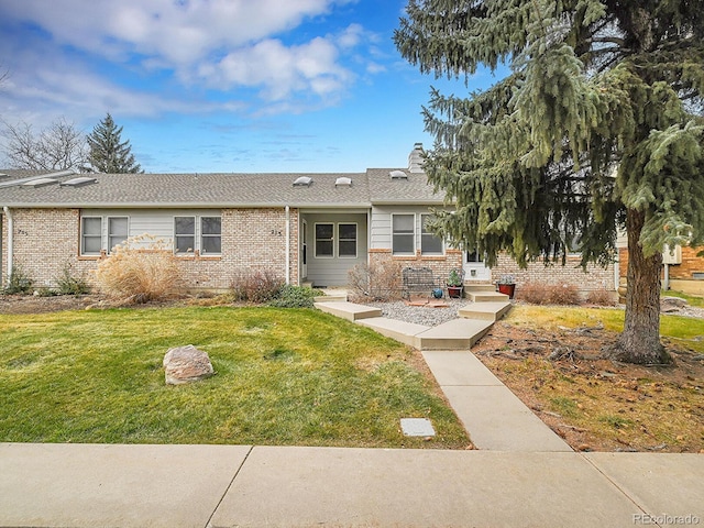 ranch-style home with a front lawn and brick siding