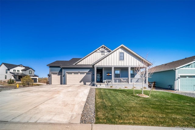 view of front of home with concrete driveway, a front lawn, board and batten siding, an attached garage, and a porch