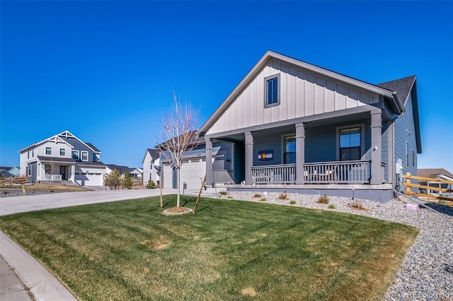view of front of home with driveway, board and batten siding, covered porch, a front yard, and a garage