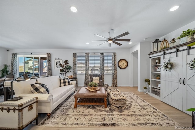 living area with baseboards, recessed lighting, a ceiling fan, and light wood-type flooring