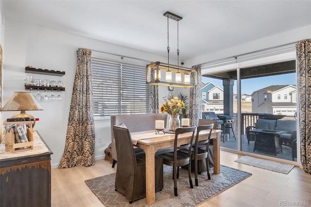 dining space featuring an inviting chandelier and light wood-type flooring