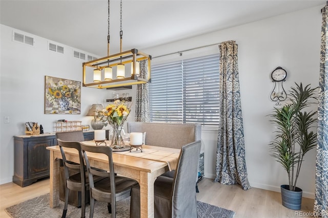 dining room featuring baseboards, visible vents, and light wood-style flooring