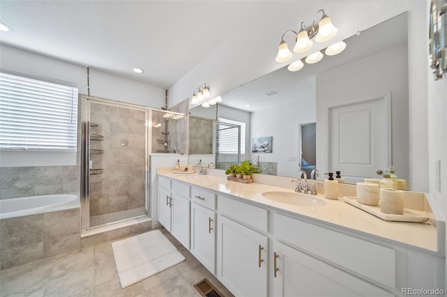 full bathroom with a bath, double vanity, a shower stall, and a sink