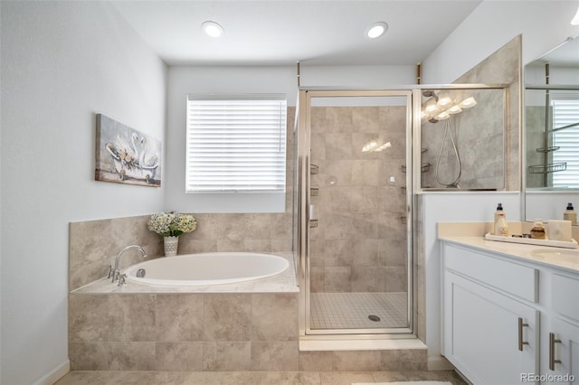 bathroom with a bath, vanity, and a stall shower