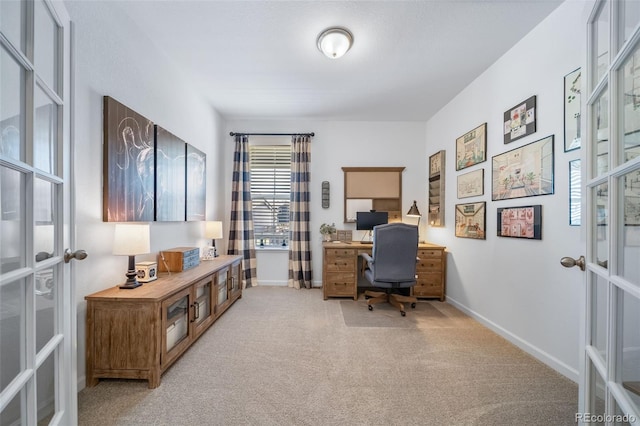office space with french doors, baseboards, and light colored carpet