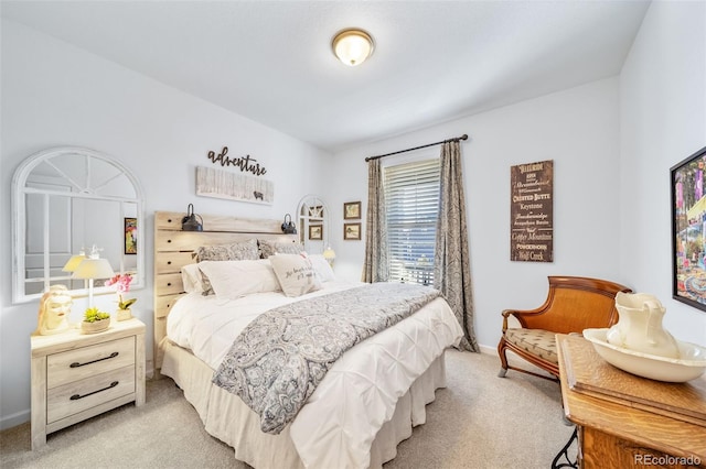 bedroom with baseboards and light colored carpet