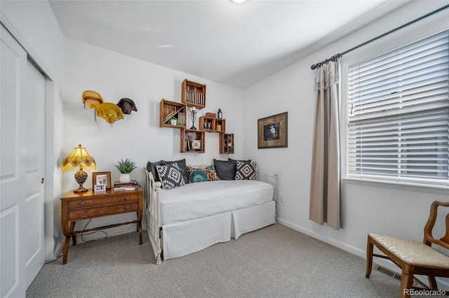 carpeted bedroom featuring baseboards, a closet, and multiple windows