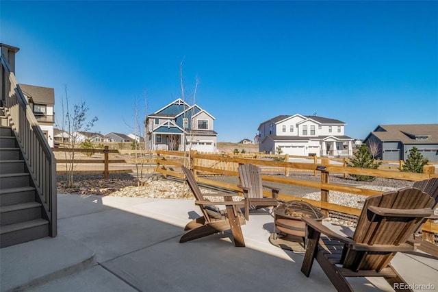 view of patio / terrace featuring a residential view, an outdoor fire pit, and fence
