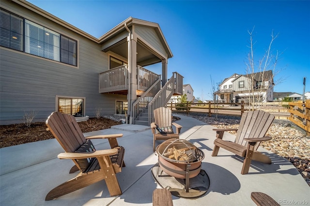 view of patio with a fire pit, stairway, and a residential view