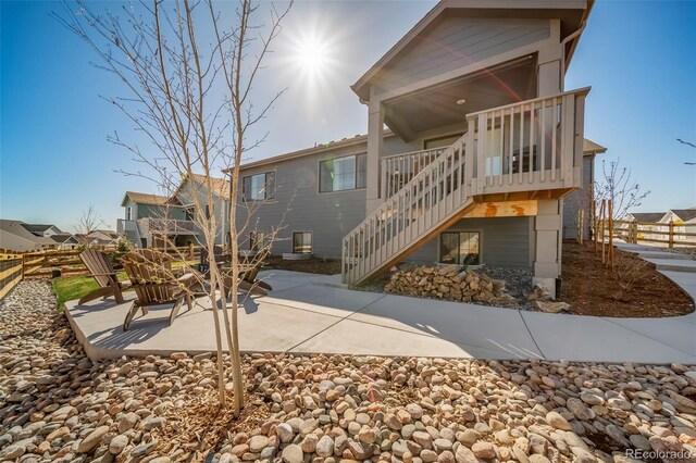 rear view of house with fence, stairs, and a patio