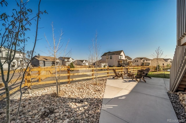 view of yard featuring fence, a patio area, and a residential view