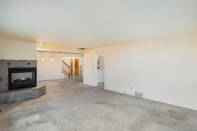 968 Terrace Cir, Colorado Springs, CO 80904 - unfurnished living room featuring carpet flooring, stairway, a fireplace, and visible vents