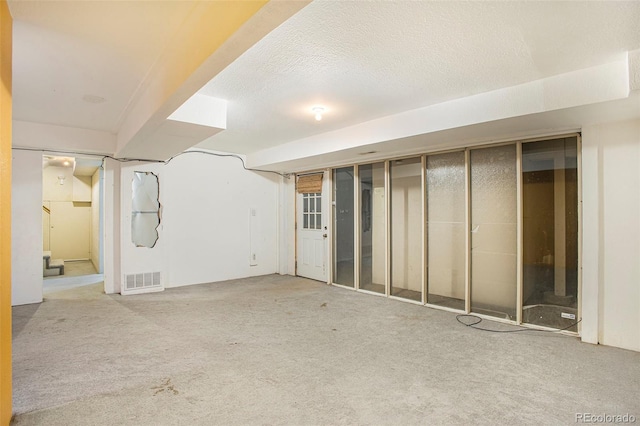 968 Terrace Cir, Colorado Springs, CO 80904 - finished below grade area with visible vents, carpet, and a textured ceiling