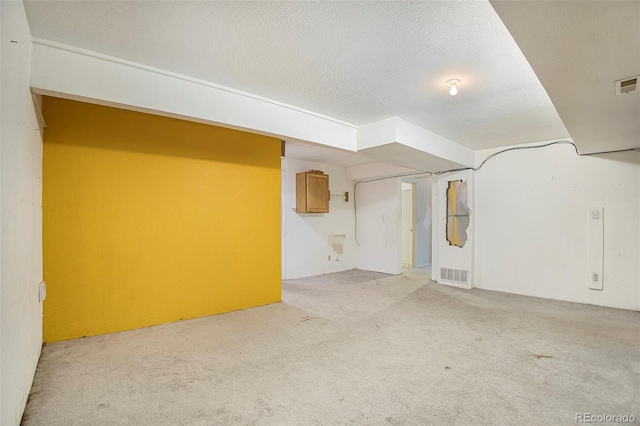 968 Terrace Cir, Colorado Springs, CO 80904 - finished basement with visible vents, light colored carpet, and a textured ceiling