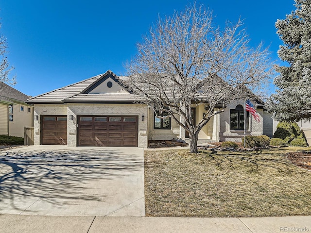 single story home featuring a garage, brick siding, and driveway