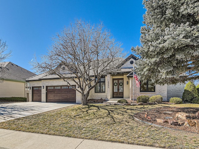 view of front of home with a garage, french doors, and driveway