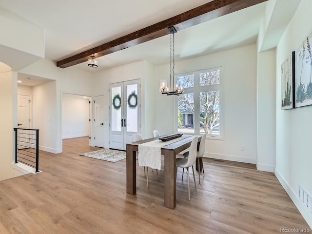 dining room with light wood finished floors, baseboards, beam ceiling, and an inviting chandelier