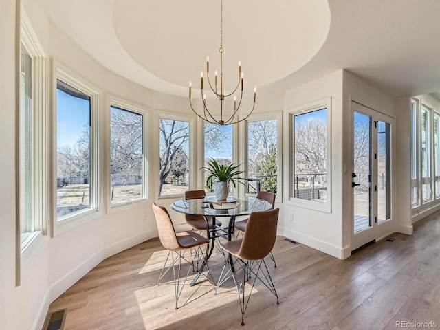 dining room featuring light wood-type flooring, visible vents, baseboards, and an inviting chandelier