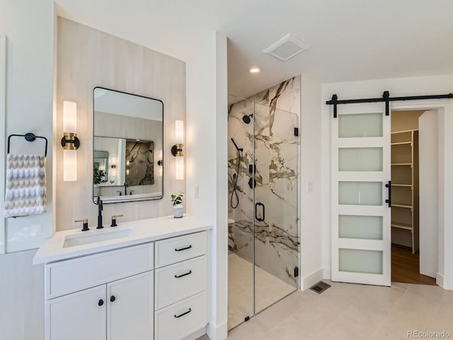 bathroom featuring vanity, a marble finish shower, visible vents, and recessed lighting