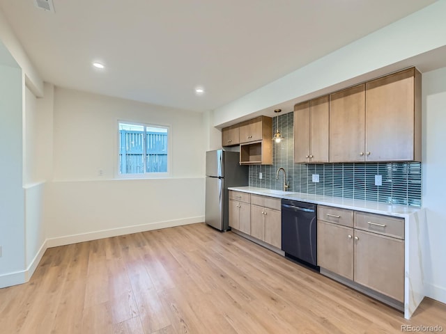 kitchen featuring a sink, light countertops, dishwasher, and freestanding refrigerator