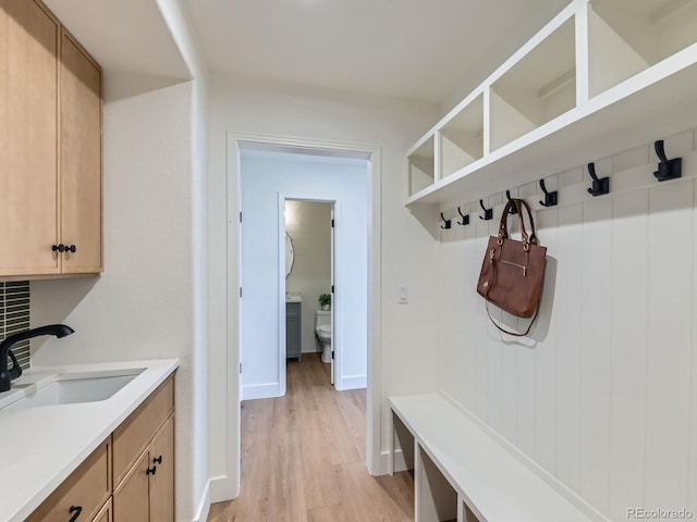 mudroom featuring a sink and light wood-style flooring