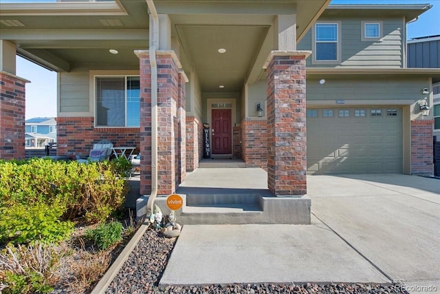 property entrance with concrete driveway, brick siding, and a garage