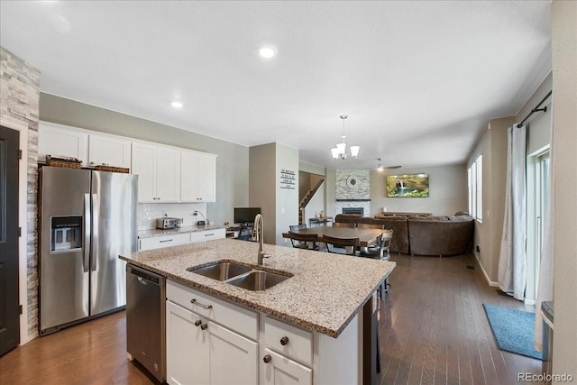 kitchen featuring a notable chandelier, appliances with stainless steel finishes, a sink, an island with sink, and open floor plan