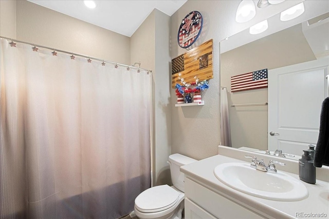 bathroom with toilet, a shower with shower curtain, and vanity