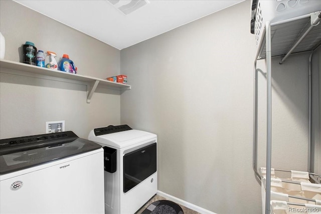 clothes washing area featuring separate washer and dryer, laundry area, visible vents, and baseboards
